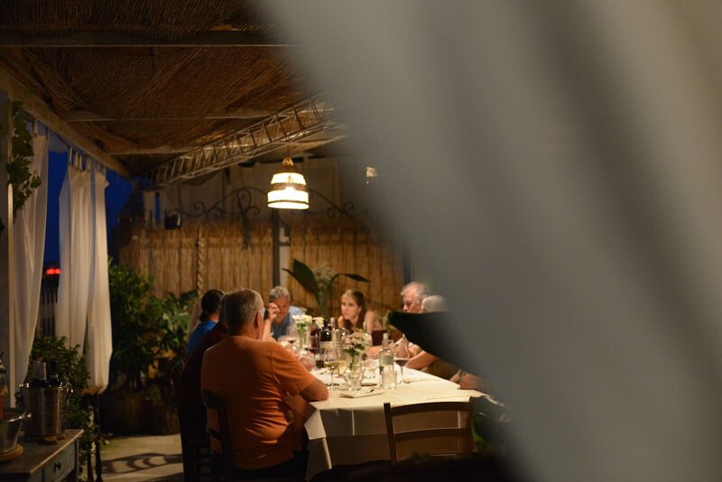 A table talking during an evening outside dinner On the Italian on Tour’s 10 day Northern Italian Delights Food & Wine Tour